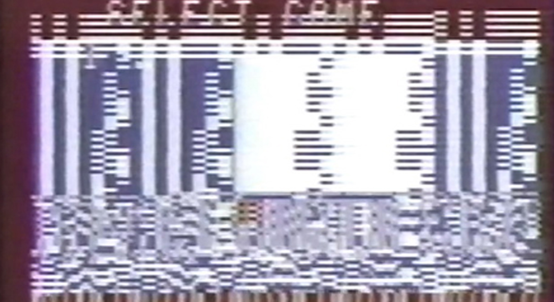 An image of a pixelated screen with static. On the center top of the image there are letters with the words “Select Game”. The letters are fading into the gray pixilation.