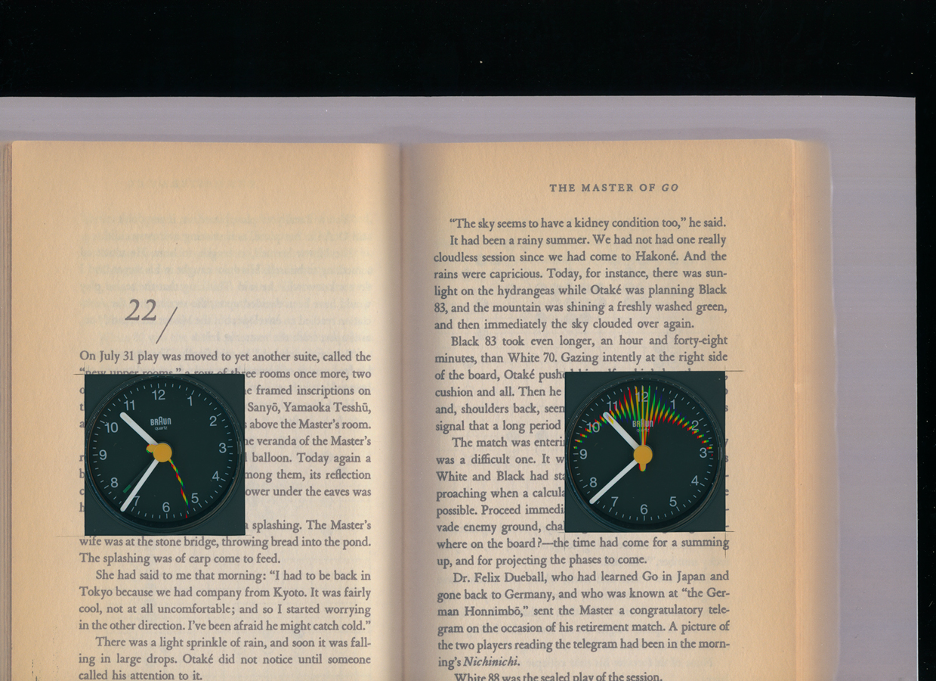 An open book with two clocks transposed on each side. Both clocks are pointing to 10:36.